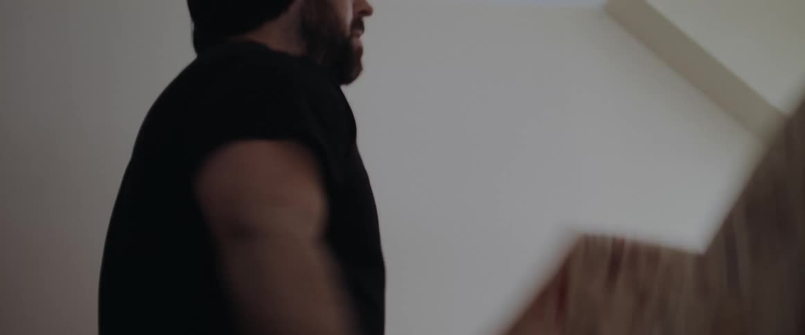 Bearded man making the bed at home
