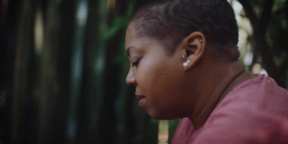 A black woman outside with her eyes closed