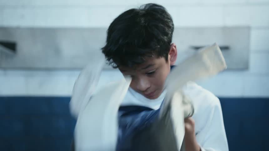 A boy taking off a fencing helmet