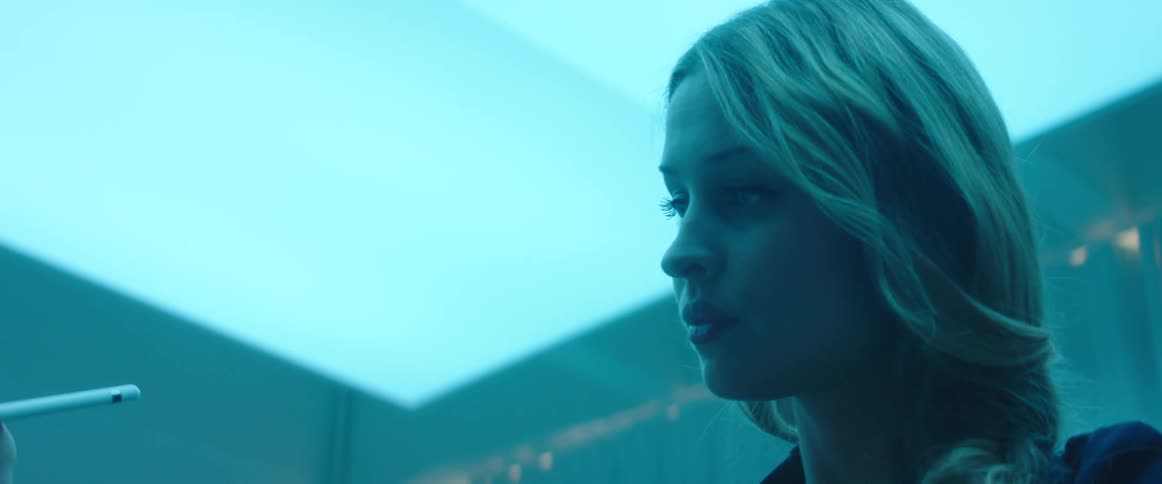 Woman drawing imaginary lines in the air with a pen inside a room under blue lights