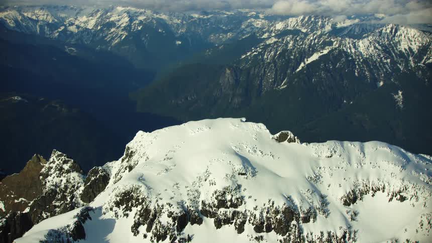 The North Cascade Mountains rise dramatically from the valley floor in Washington State under heavy snow in the winter