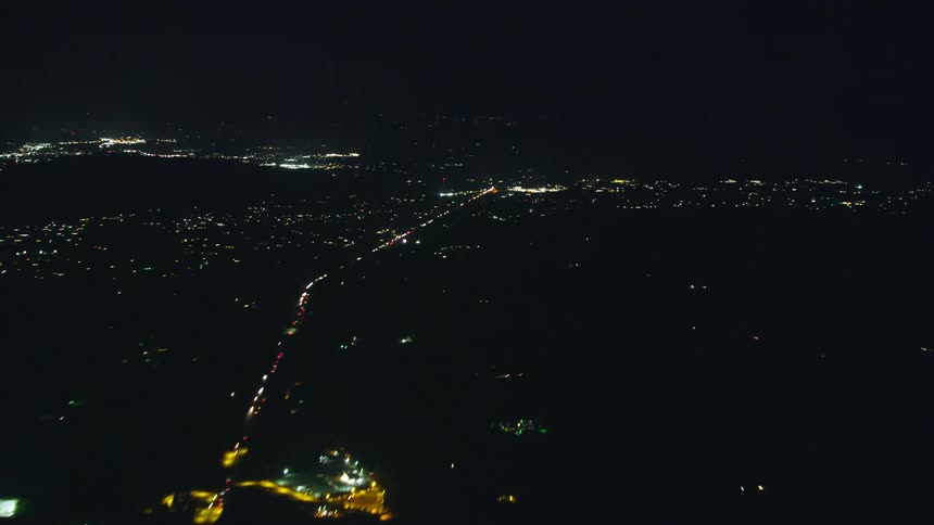 Night time lapse aerial of traffic driving out of Portland Oregon under a vast and black night sky