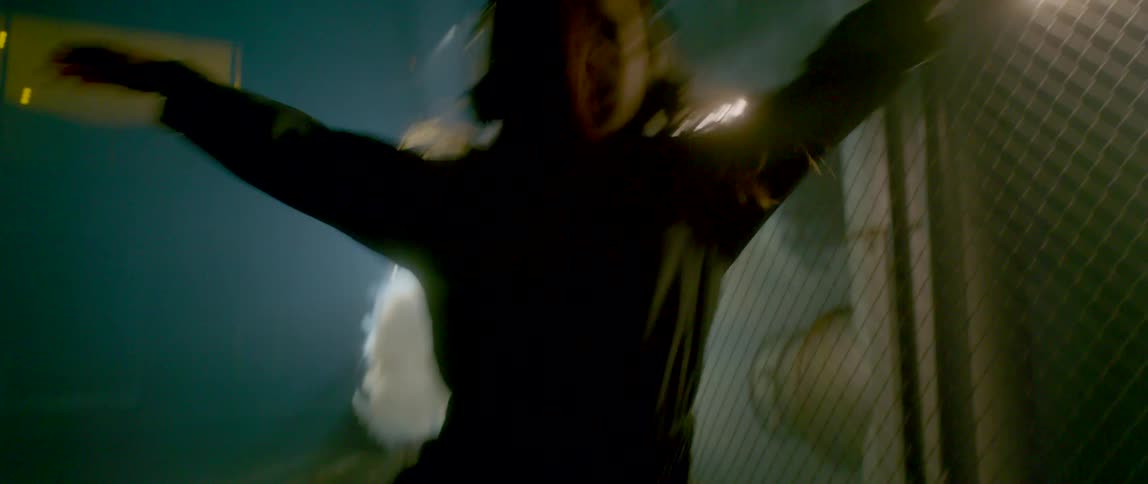 A girl wearing headphones dances aggressively with smoke billowing behind her