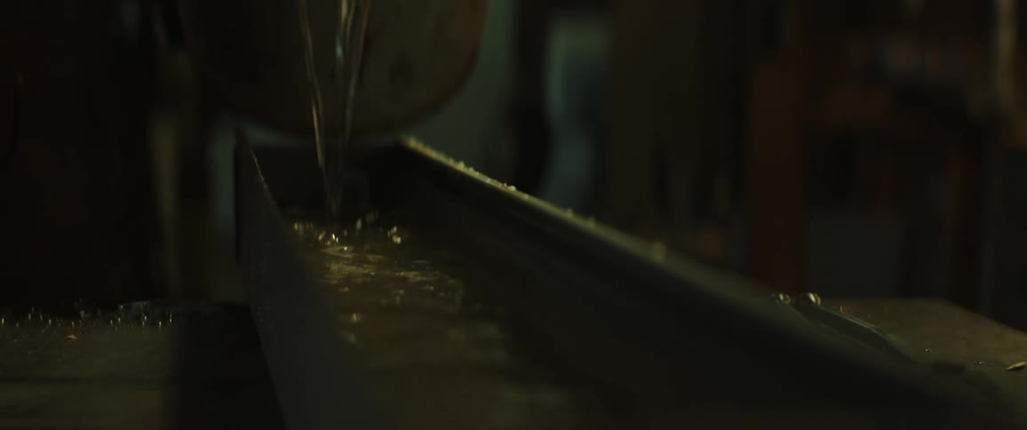 A person pouring a bucket of water down a chute