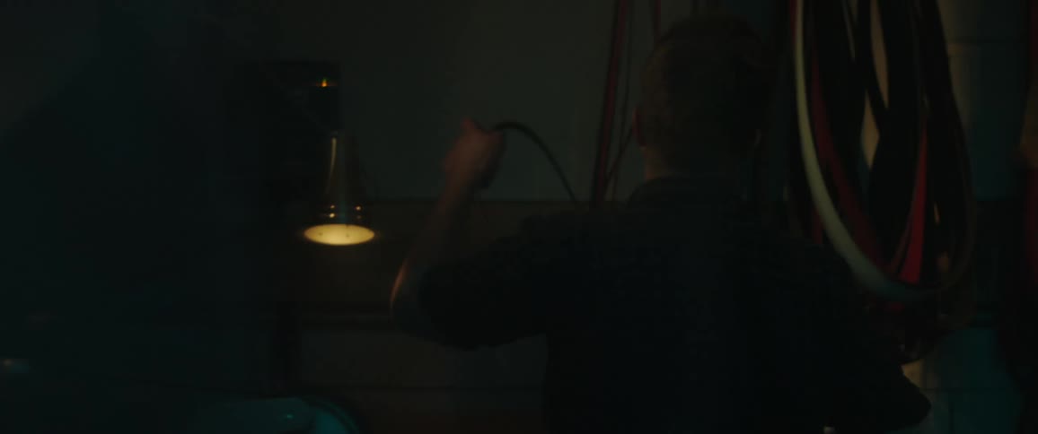 A man hangs a belt on a hook in the shop