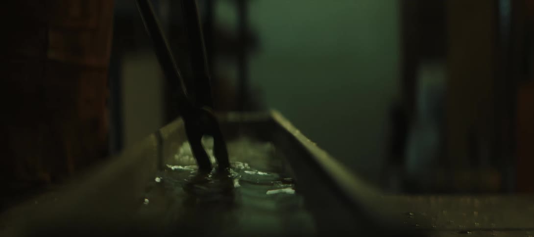 A blacksmith puts a piece of hot metal in the water to cool