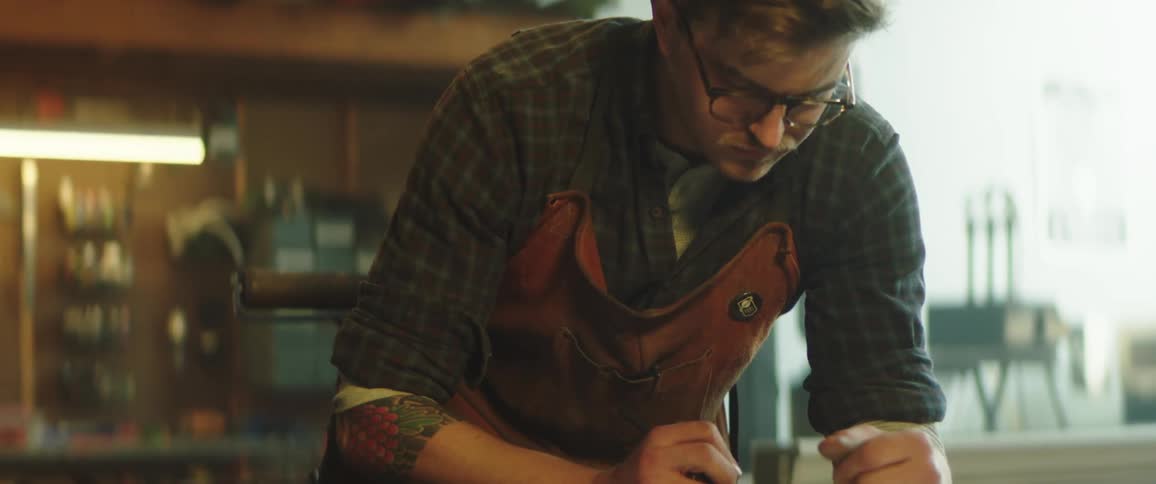 Man drawing over a piece of wood over a workbench in the workshop