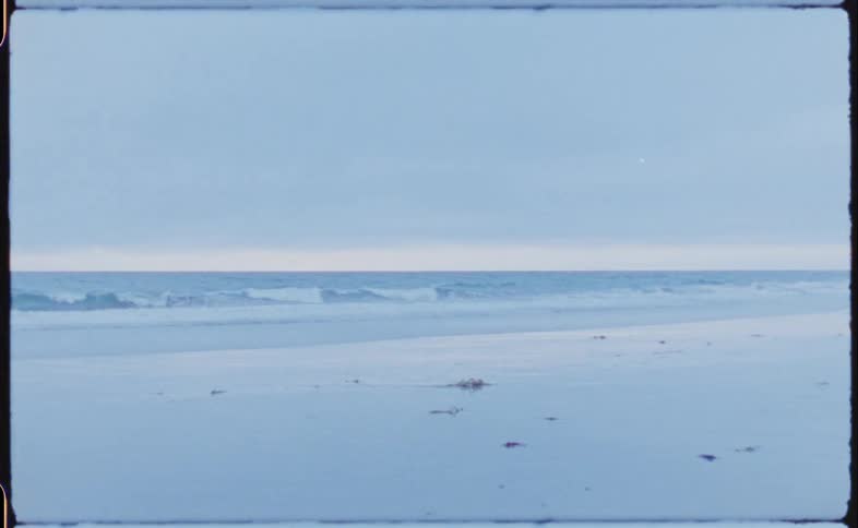 Ocean waves crasing on the shoreline caught on vintage film