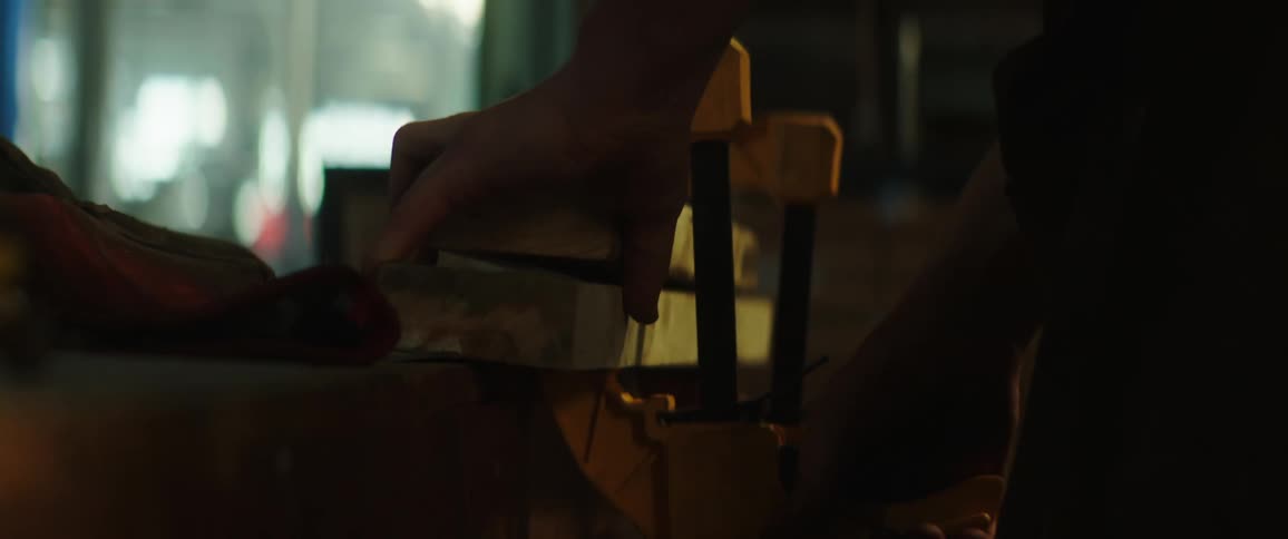 A warehouse employee clamps two pieces of wood together