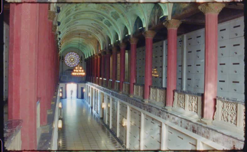 A person enters the long hall from outside