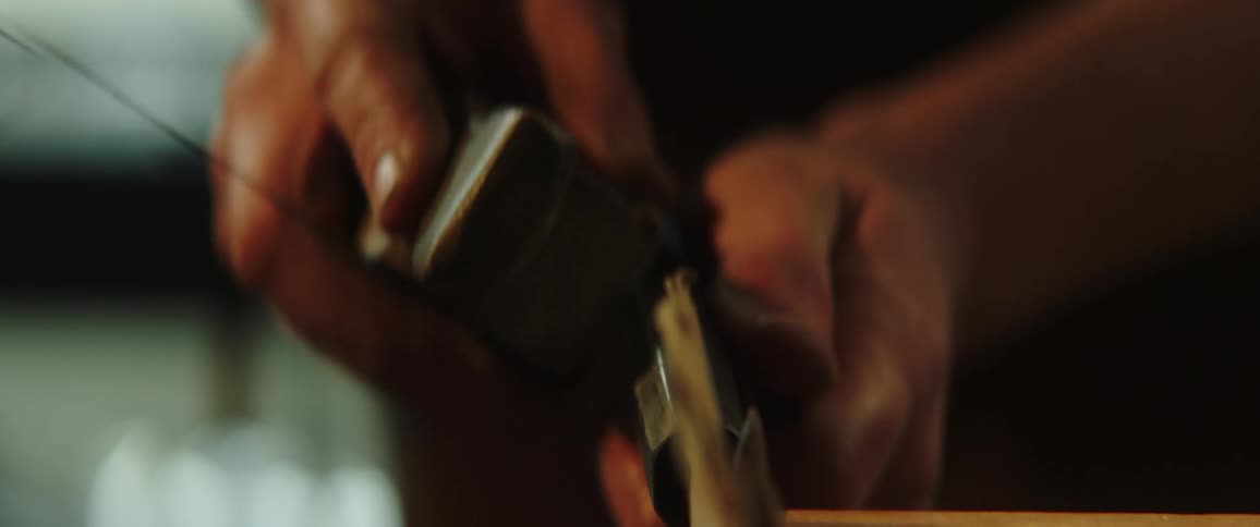 A person polishing a piece of metal with a tool