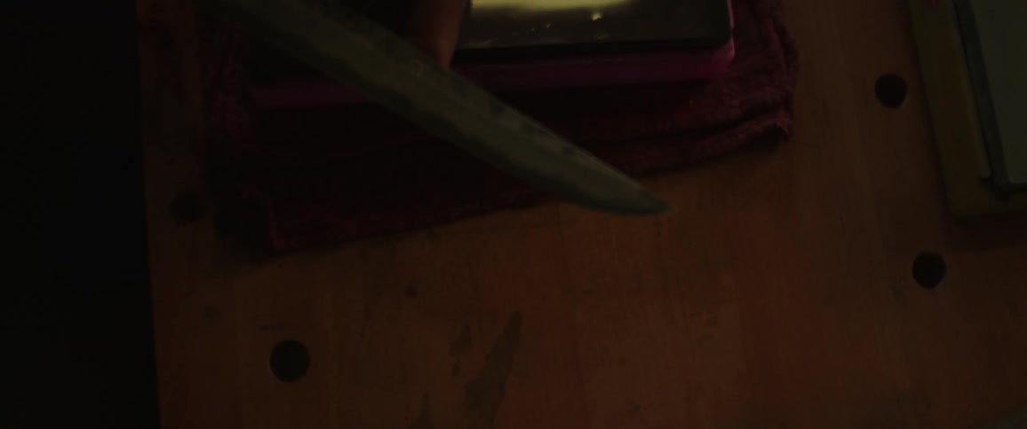 A man closely examines the blade of a knife