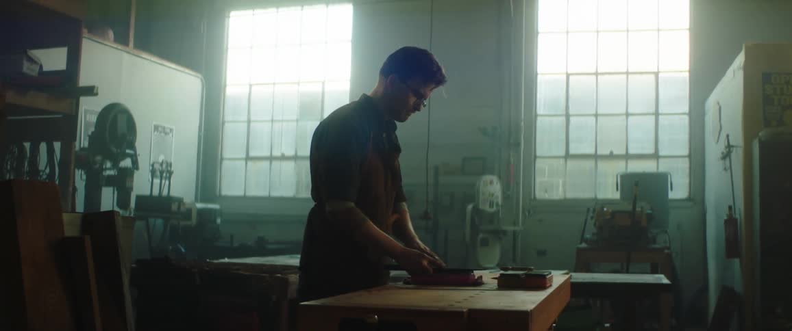 A man in a workshop sands