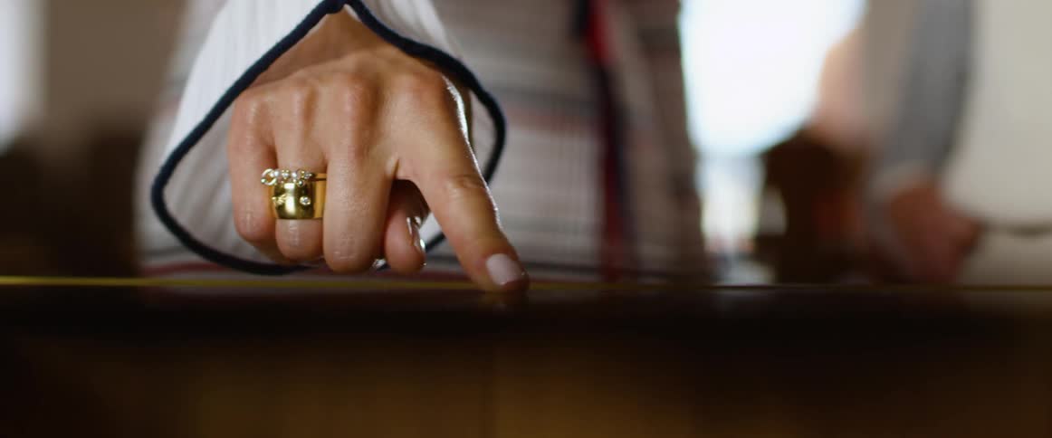 Woman pointing at jewelry behind a glass in a store