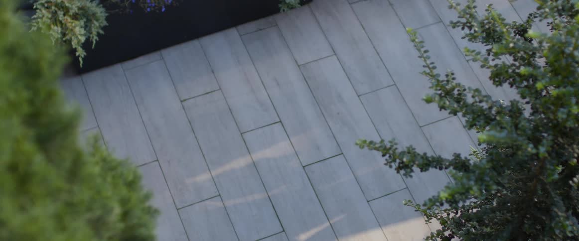A couple walks down a tiled path outdoors at daytime