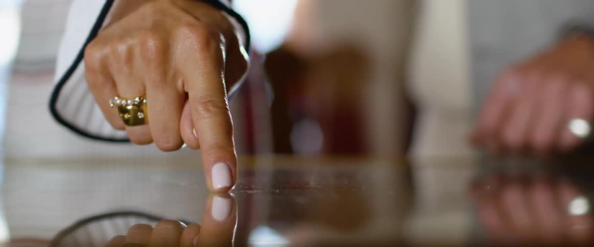 Woman sliding a finger tip over a reflective surface