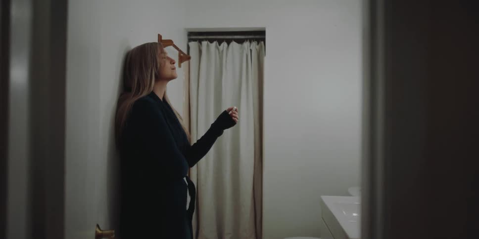Blonde woman looks at pregnancy test in the bathroom