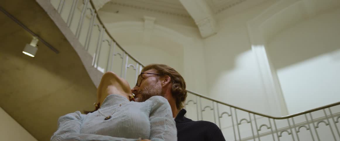 Husband is holding his wife inside of a building