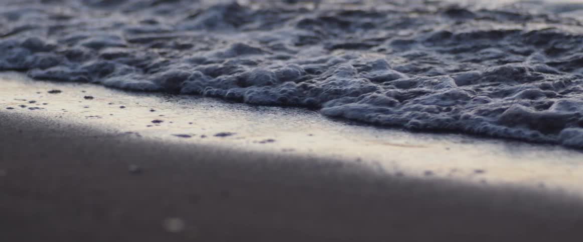 A wave rolls in on a beach