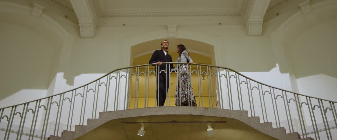 A couple climb the stairs and hug at the top
