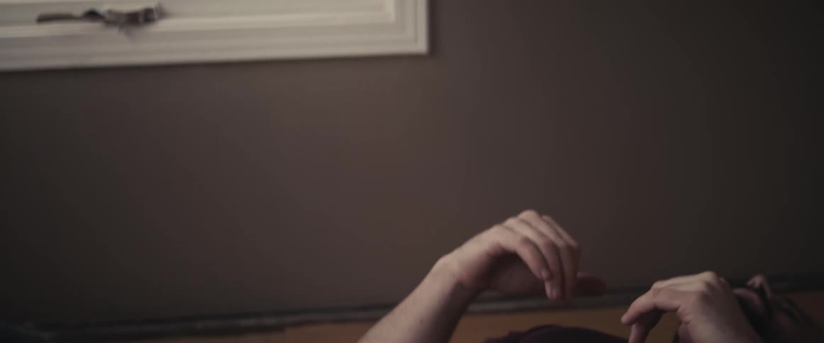 A man on the floor of a room doing situps with a wall and window in the background