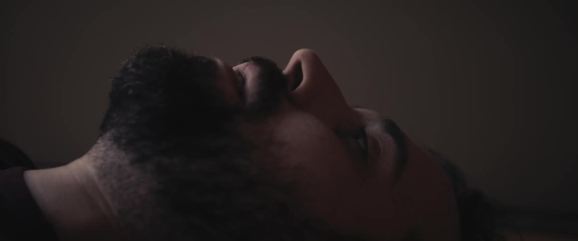 Man with a beard lies down on the floor and breathes