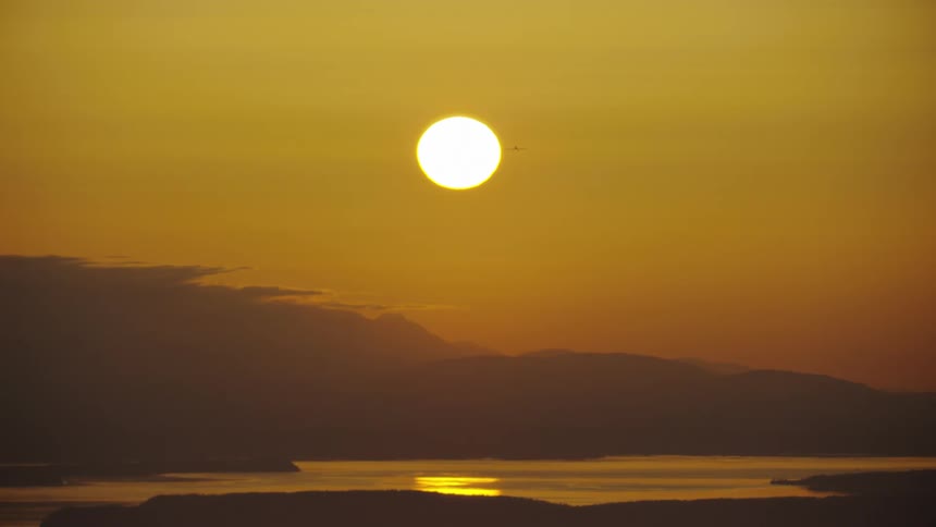 A small single engine aircraft eclipses the sun with the Pacific Ocean in the background after a great day of flying