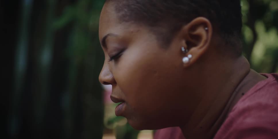 Profile of a woman sitting outdoors praying with eyes closed