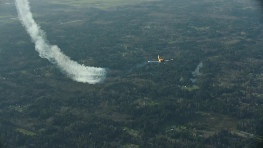 A single engine passenger airplane leaves signature vortices in its wake while flying high above the ground