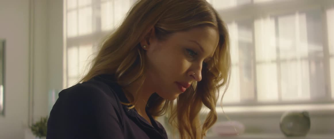 Side view of blonde woman with nose piercing looking down
