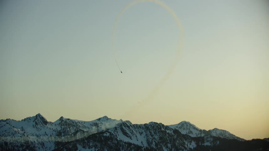 This acrobatic airplane does a loop with  smoke giving an awesome perspective as the sun is setting