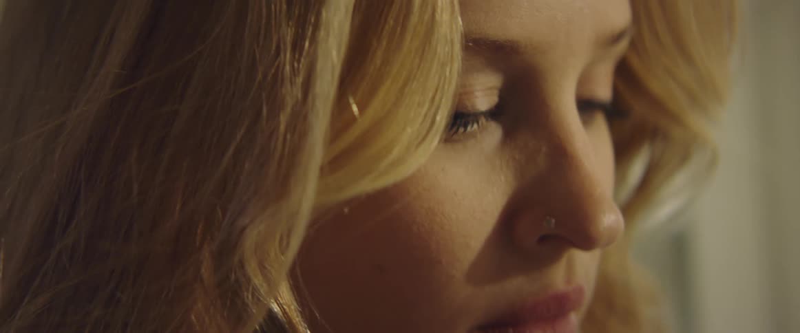 A woman with blonde hair staring down
