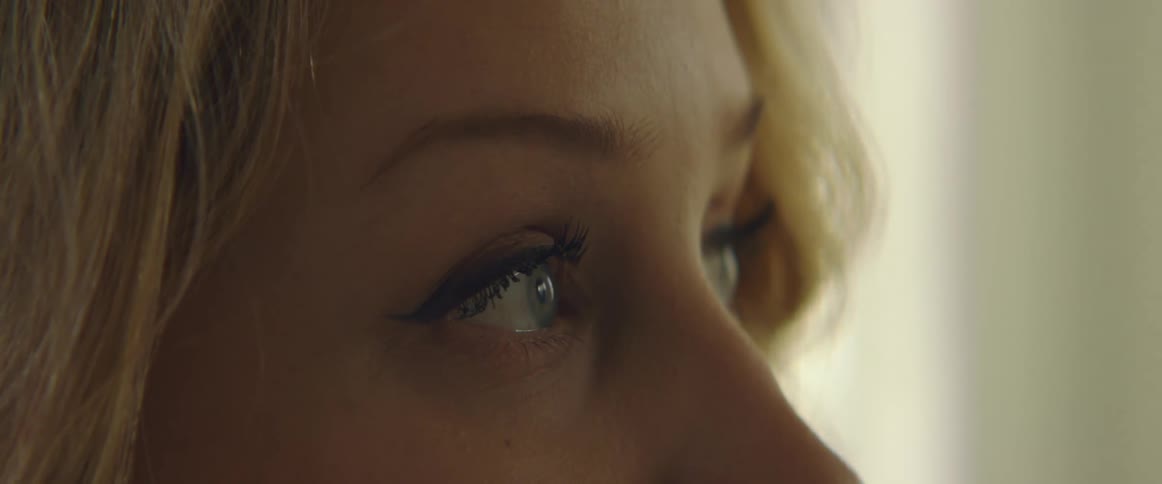 Side view of blonde woman with a nose piercing looking up