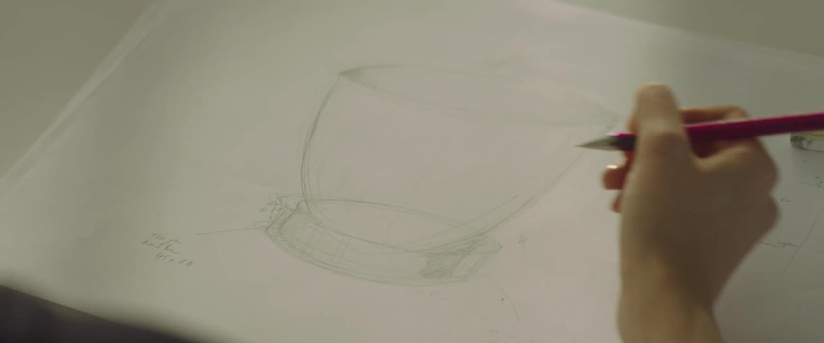 A person is drawing a design for an item
