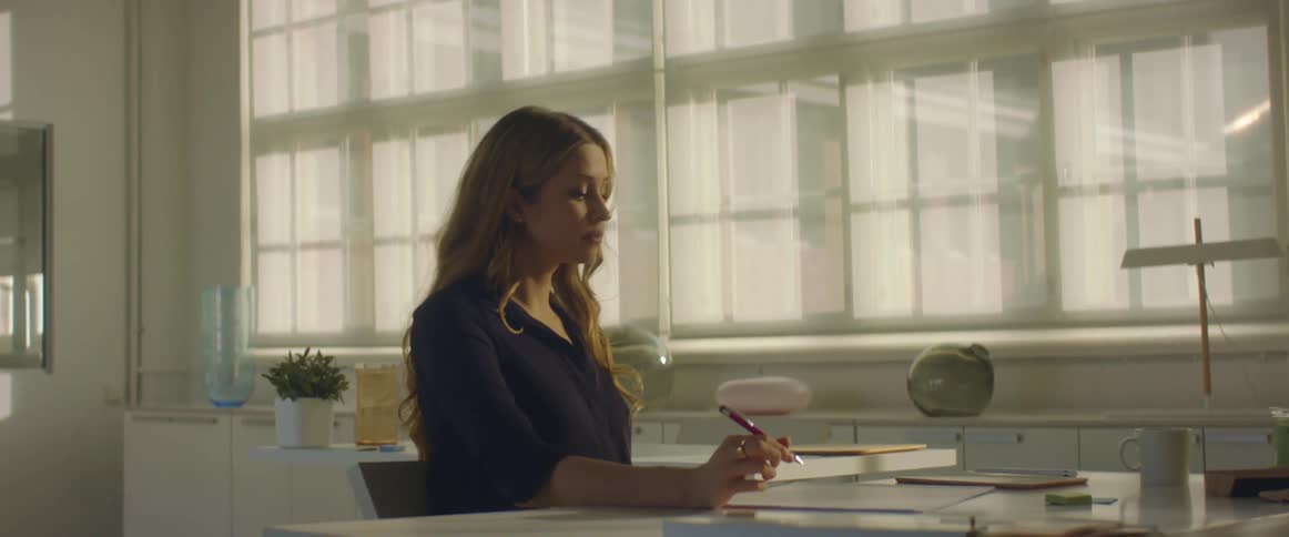 Woman sitting at a desk in the office drawing with a mechanical pencil