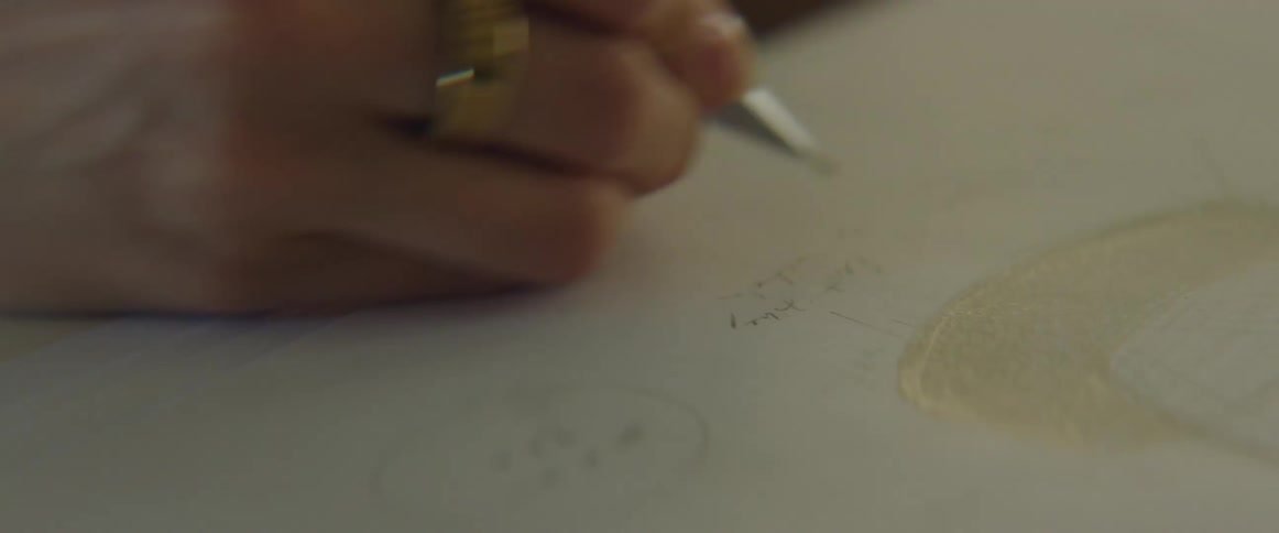 A woman writes on a paper underneath a drawing