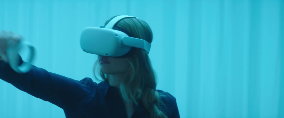 Blonde woman wearing virtual reality headset moves controller around