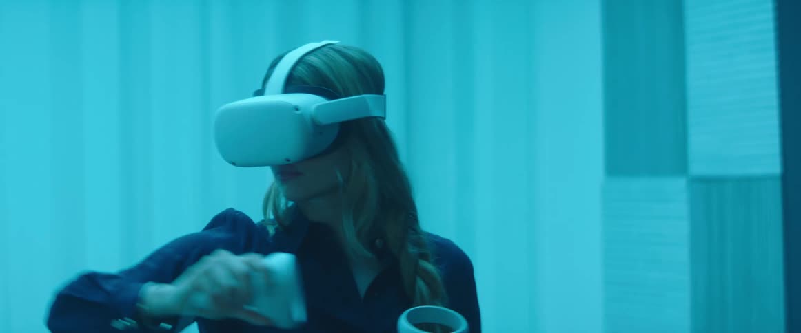 A woman in a room with a virtual reality headset with a wall in the background