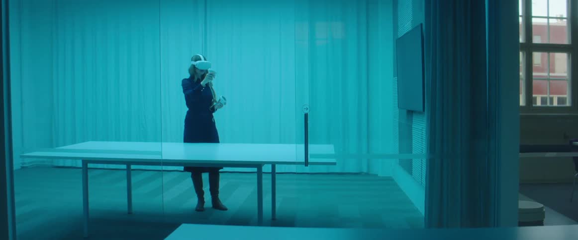 A woman plays a virtual reality game in a large room by herself