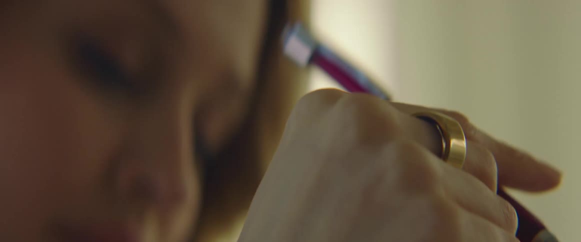 A woman moves a pen up and down between her fingers