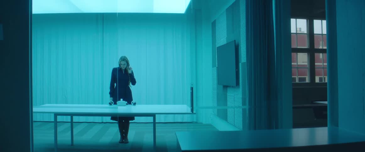 Woman testing virtual reality goggles and controls inside an office