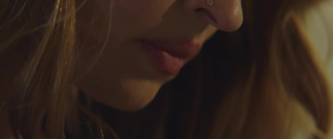 Side view of blonde woman with nose piercing looking down