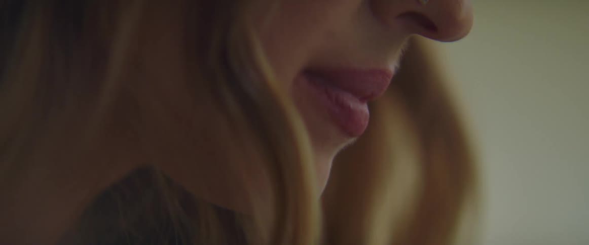 Blonde woman with nose jewelry smiles