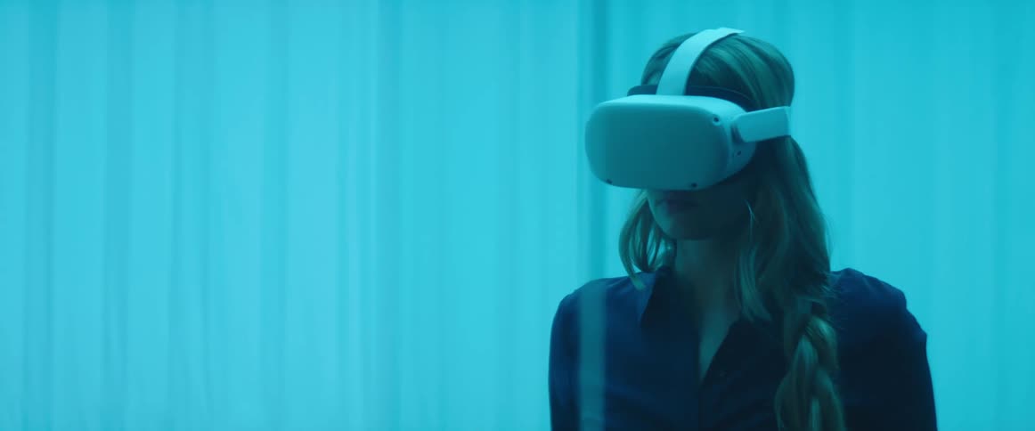 A woman is looking around while wearing a virtual reality headset