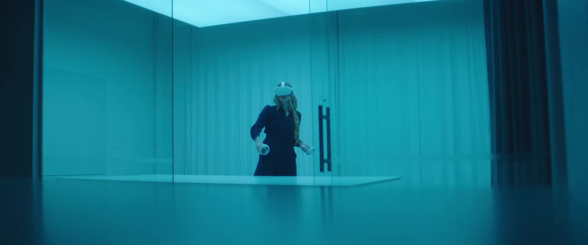 A woman stands in a large office room playing a virtual reality