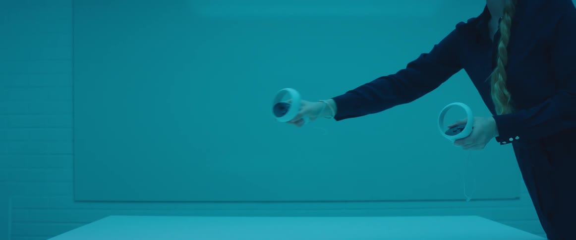 A woman in a room holding controls with a wall in the background