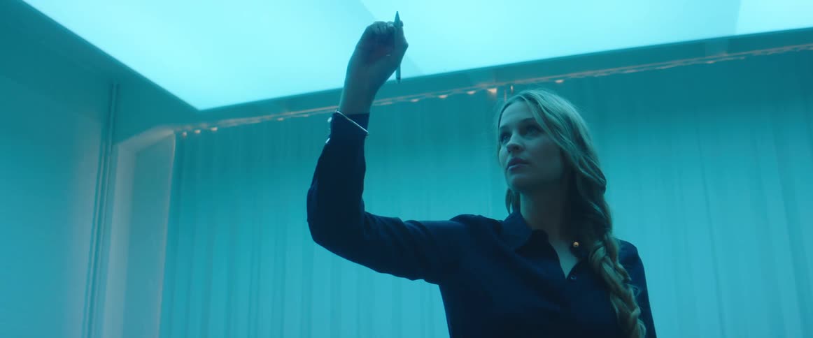 A woman is tracing a writing instrument in the air