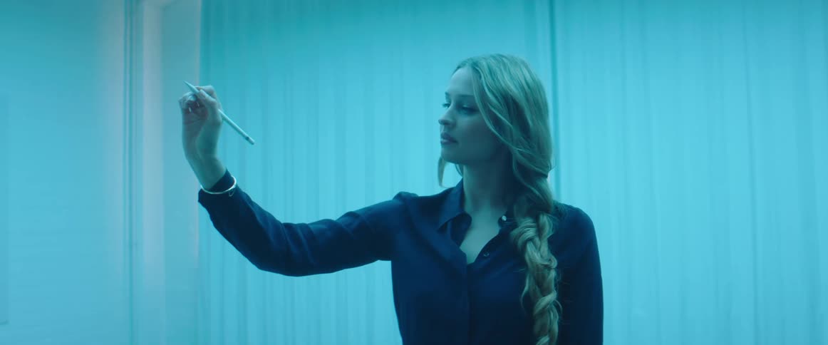 A woman draws in the air with a pen and smiles