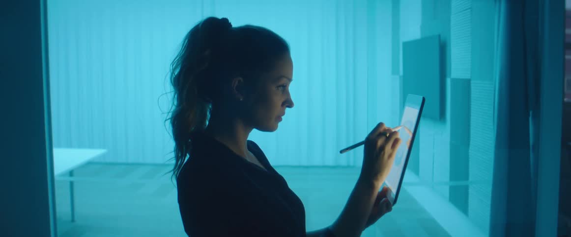 Woman writing on a tablet with a stylus inside an office