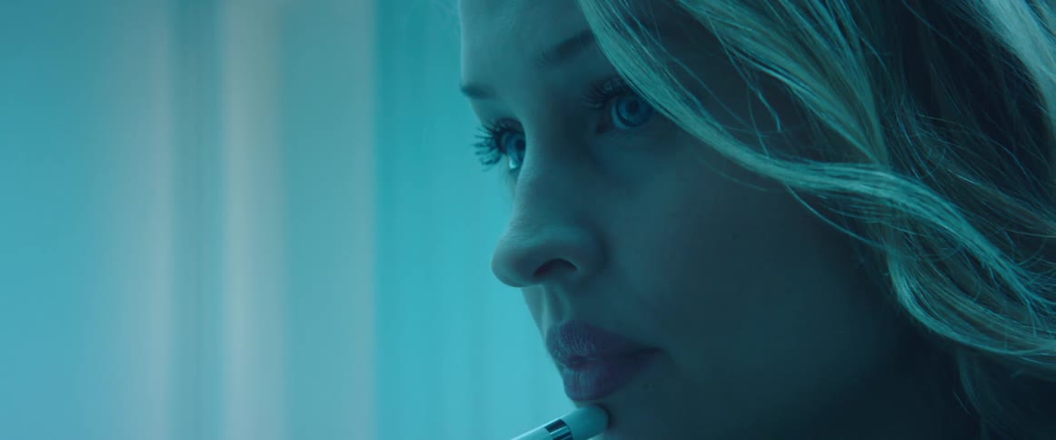 A woman puts a pen to her chin while thinking